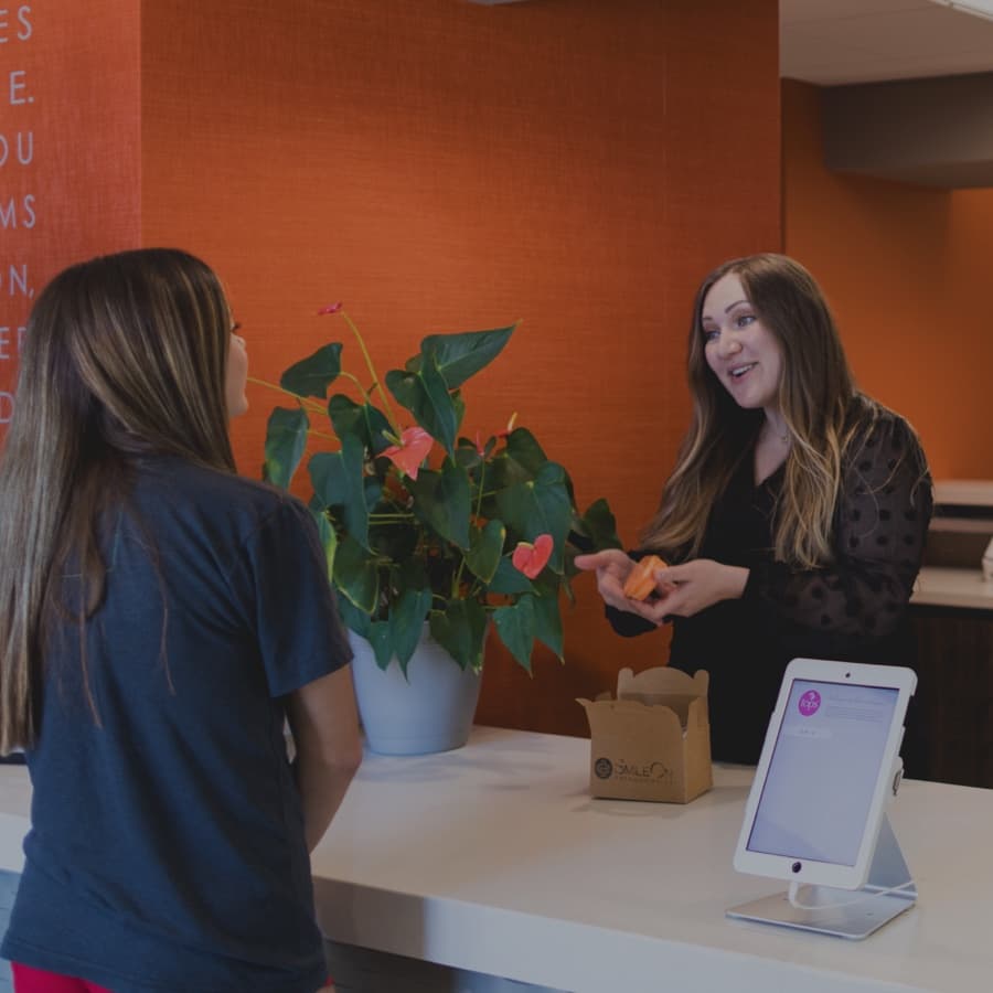 patient talking with front office staff member